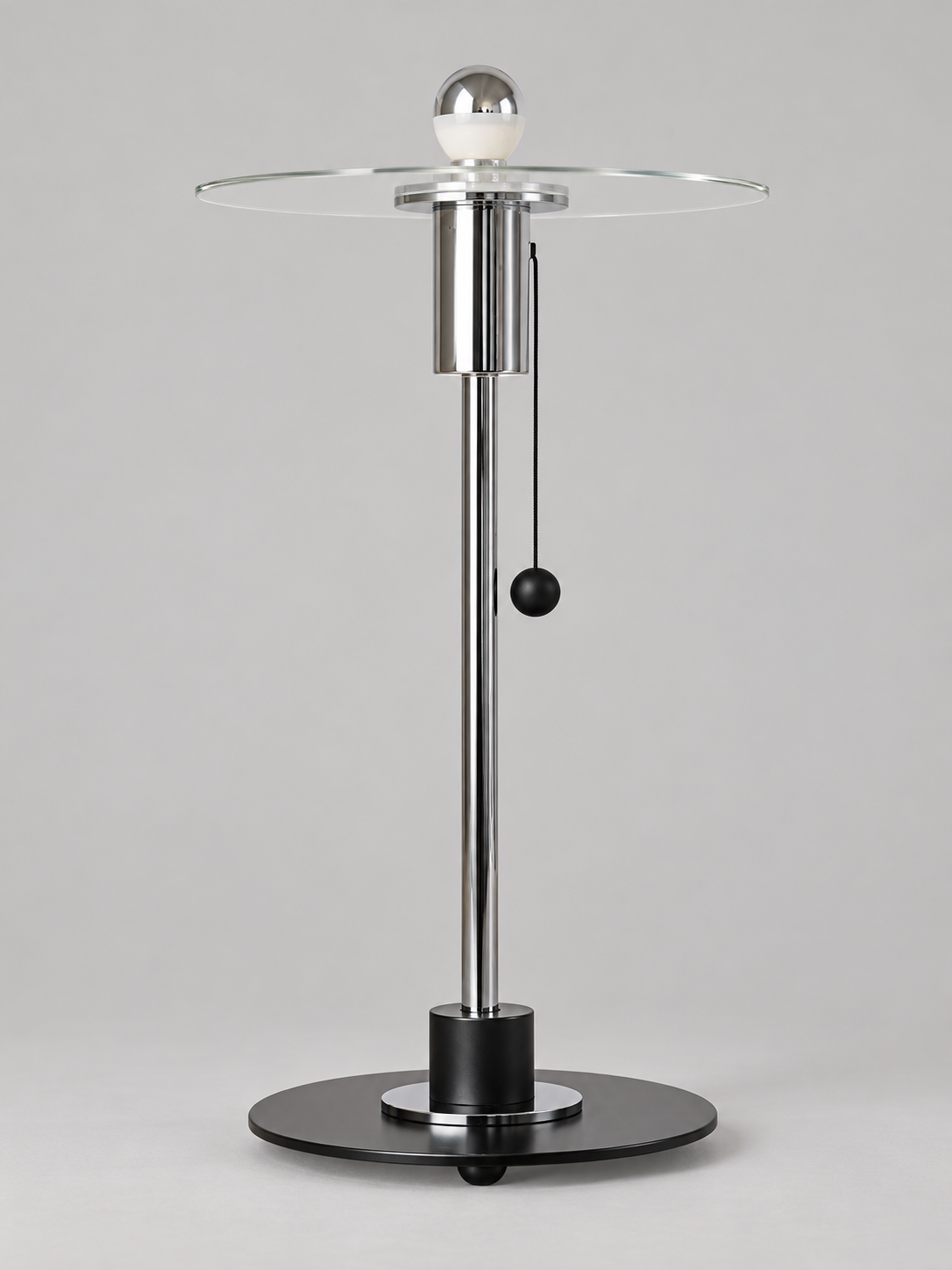 Clear glass disc table lamp with half-chrome bulb finish and chrome-tone fittings, shown unlit