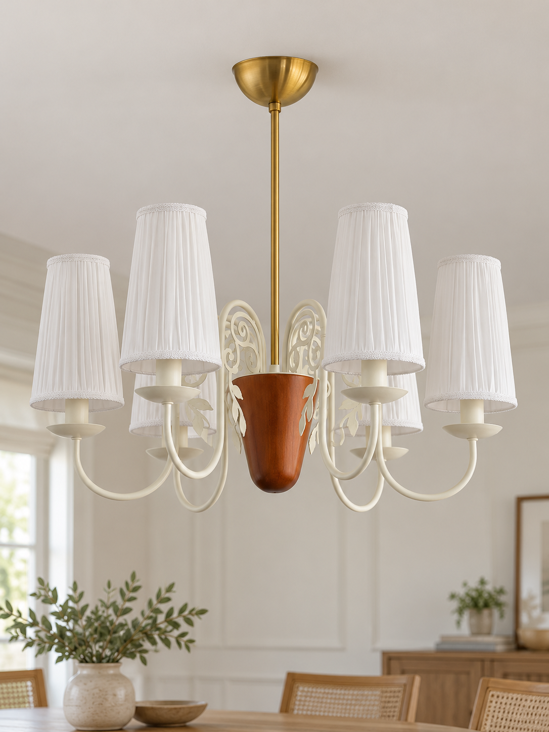 Scroll-arm chandelier with 6 white pleated fabric shades, shown unlit, daylight dining-room setting