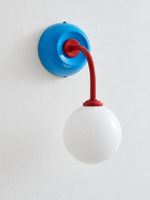 Blue + Red wall sconce with curved red arm and white glass globe, shown unlit, complete-fixture detail view