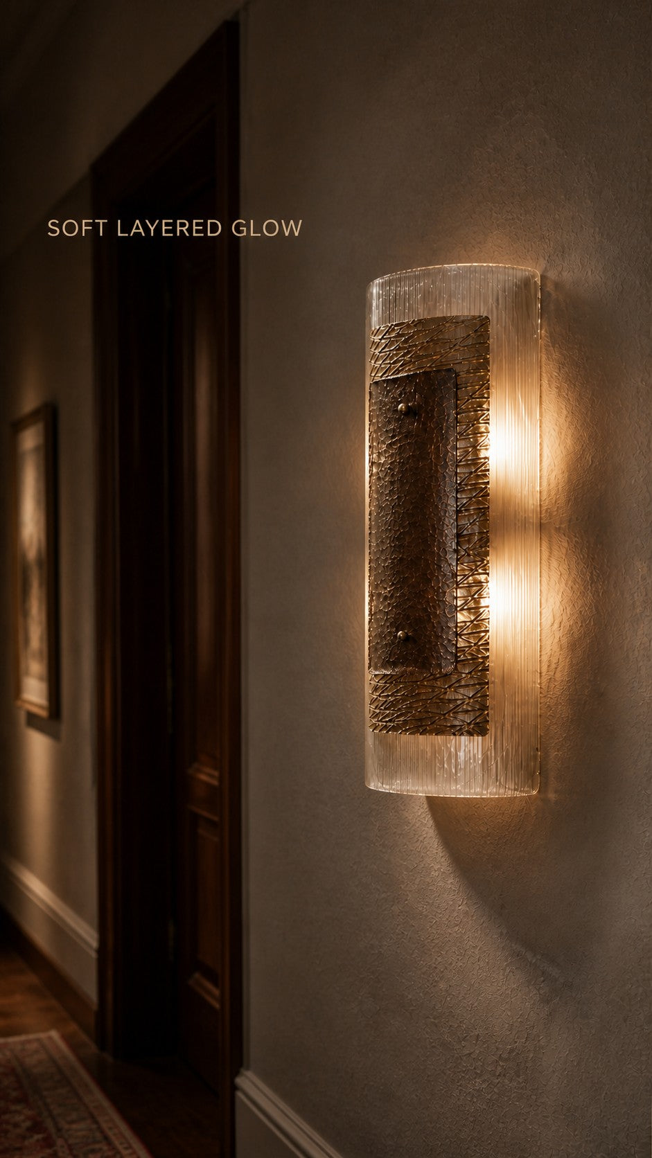 Warm light passing through the Cinder Veil ribbed glass wall sconce