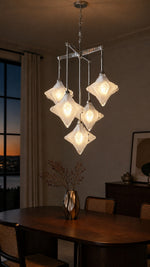Stella Fold chandelier glowing above a dining table