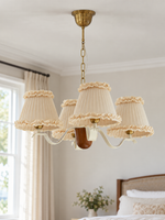 Round 4-light chandelier with cream ruffled fabric shades, shown switched off in daylight