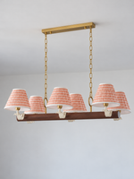 Linear 6-light chandelier with red-and-white striped fabric shades, shown switched off in daylight