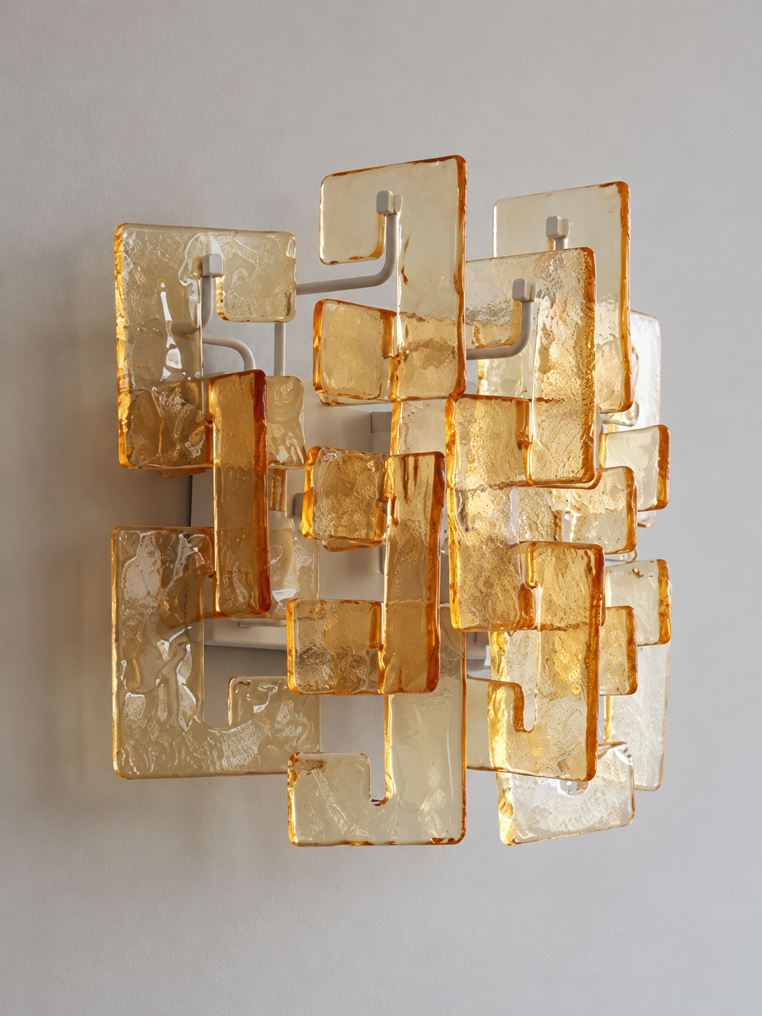 White wall sconce with amber textured glass panels, shown switched off in daylight