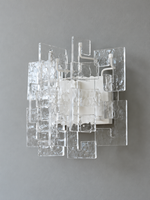 White wall sconce with clear textured glass panels, shown switched off in daylight