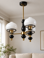 Black and copper-tone 3-light chandelier with white glass shades and bell finials, shown switched off