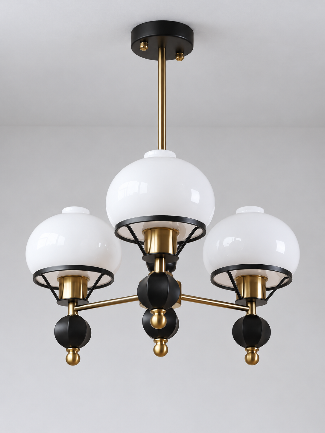 Black and copper-tone 3-light chandelier with white glass shades and faceted finials, shown switched off