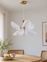 Large 36 cm white acrylic petal pendant with copper-tone frame, switched off above a daylight dining nook