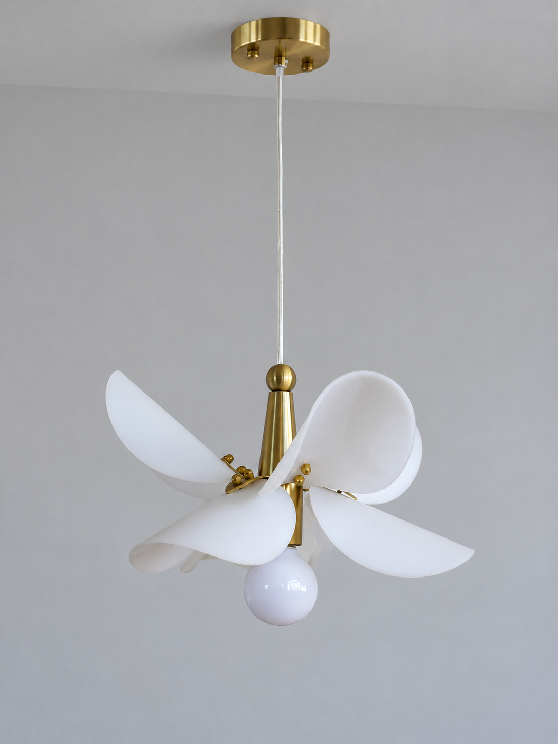 Small 32 cm petal pendant showing white acrylic curves and copper-tone fittings, switched off