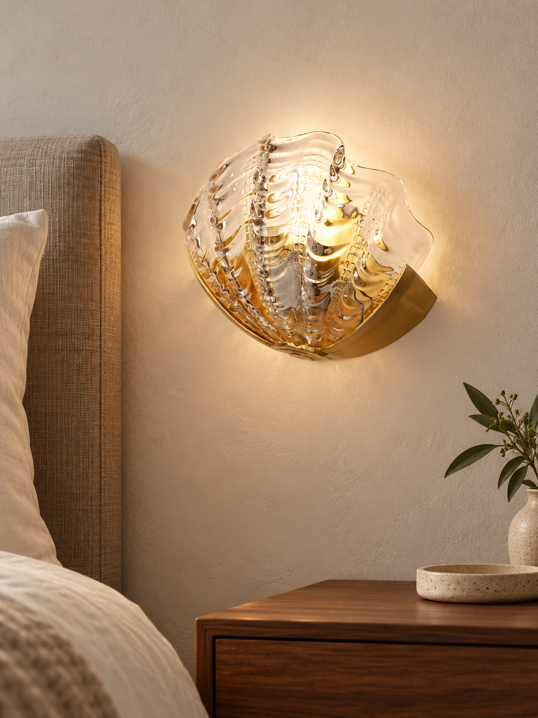 Ribbed shell glass wall sconce in a bedroom setting