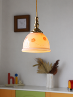 Pink floral glass pendant illuminated in a room setting