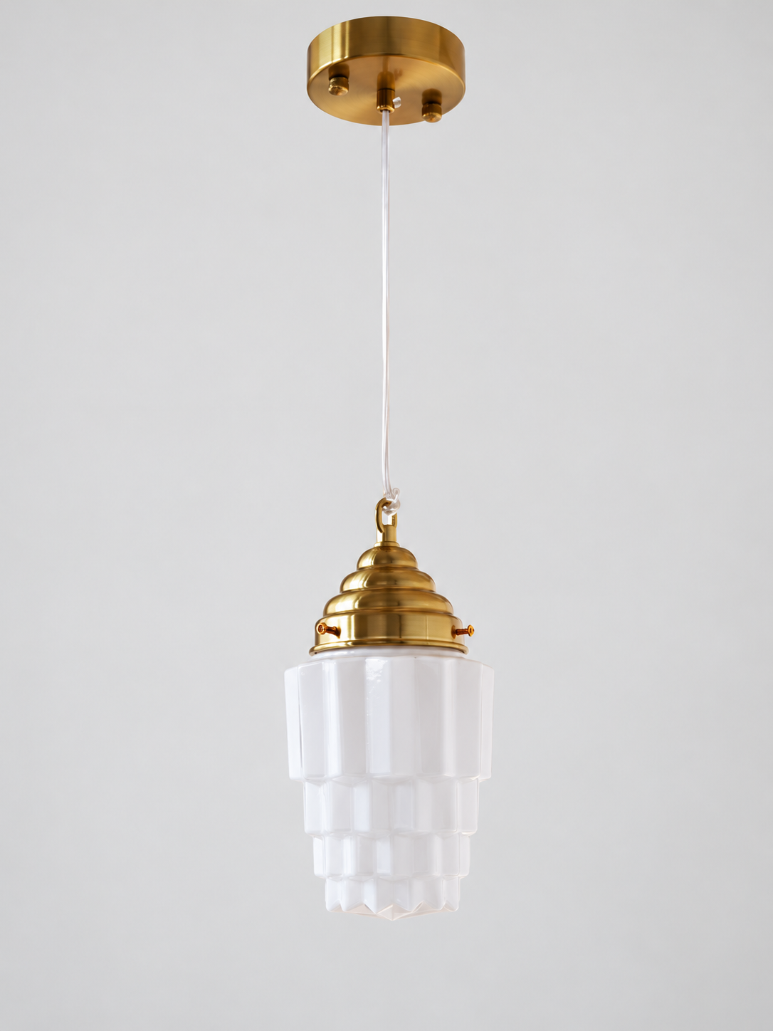 Copper-tone faceted stepped white glass pendant