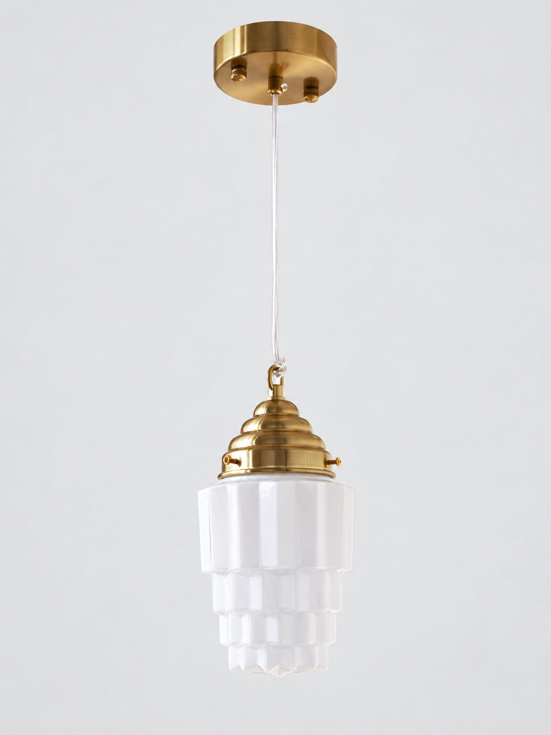 Copper-tone faceted stepped white glass pendant
