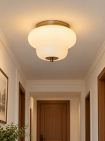 Copper-tone rounded tier white glass ceiling light in a room setting