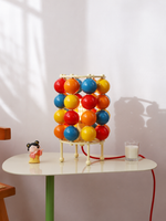 Colorful sphere table scene with cream metal frame and red cord