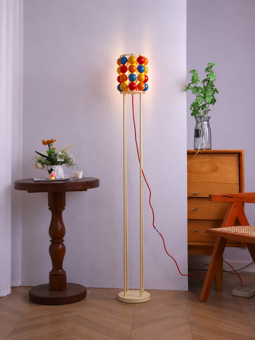 Colorful sphere floor scene with cream metal frame and red cord