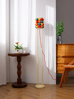 Colorful sphere floor daylight with cream metal frame and red cord
