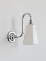 Chrome bent arm wall sconce with a white ceramic shade, shown unlit