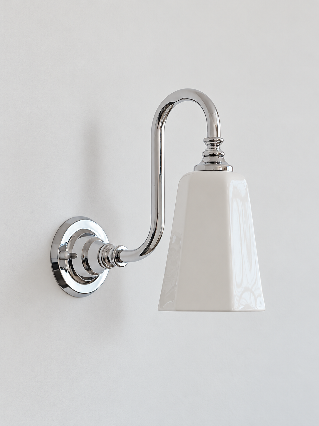 Chrome bent arm wall sconce with a white ceramic shade, shown unlit