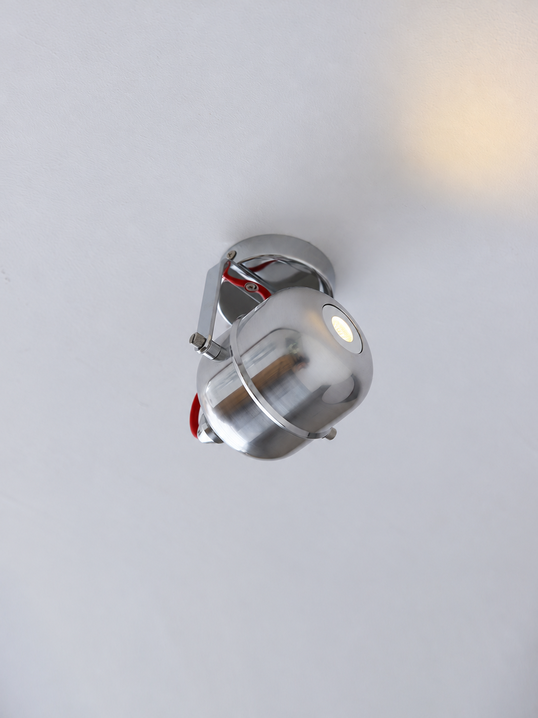 Chrome capsule ceiling spotlight, red tilted