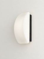Curved white glass and black wall sconce, side view