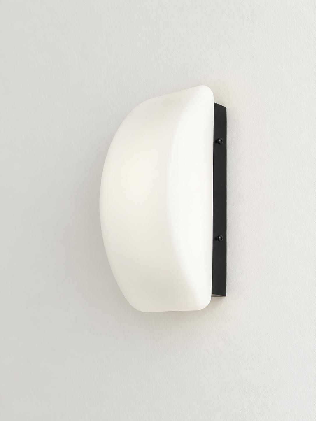 Curved white glass and black wall sconce, side view
