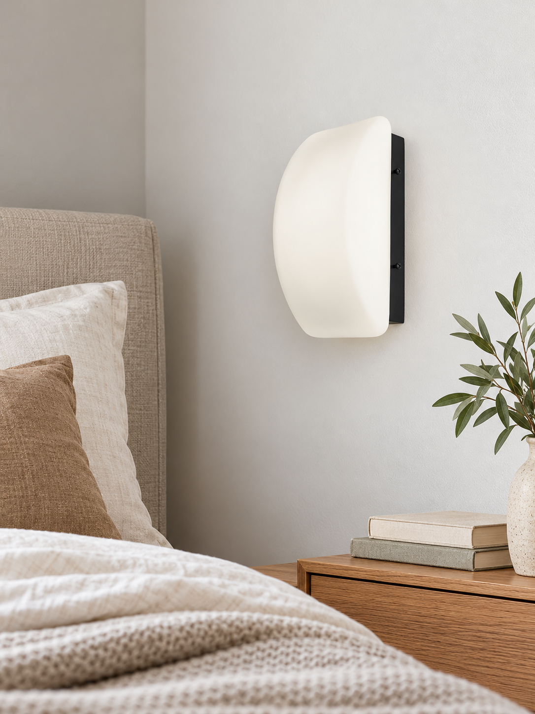 Curved white glass and black wall sconce, bedside view