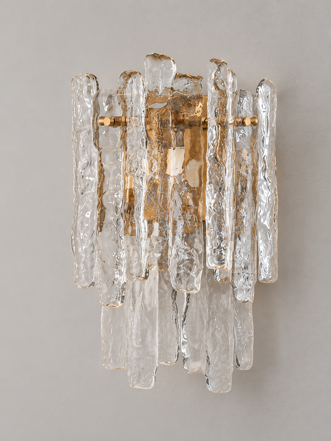 Clear textured ice glass wall sconce with copper-tone frame, angled view