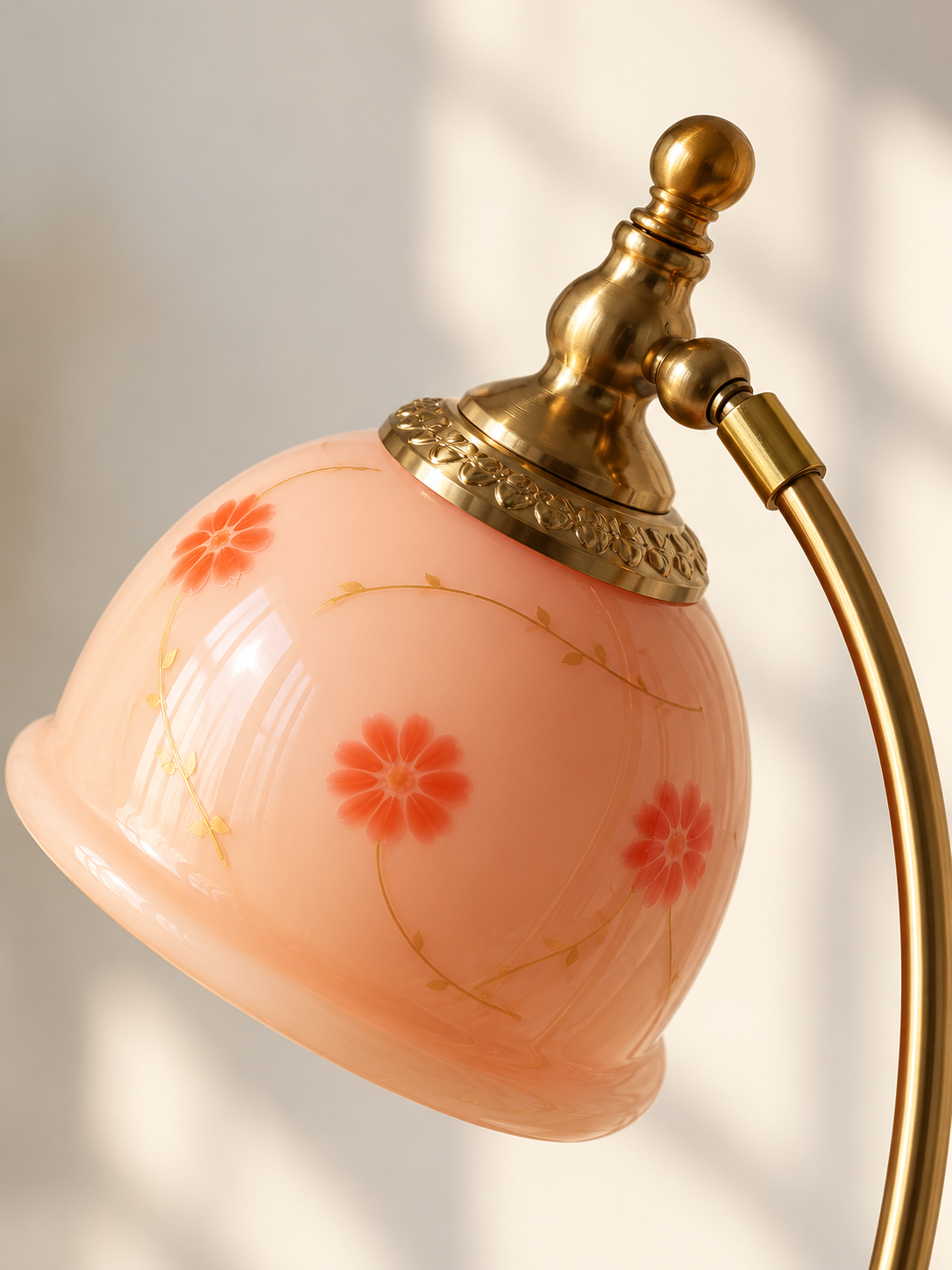 Close-up of the blush pink floral glass shade, rolled rim and decorative copper-tone collar