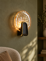 Halo Crest round amber textured glass LED wall light beside a reading chair
