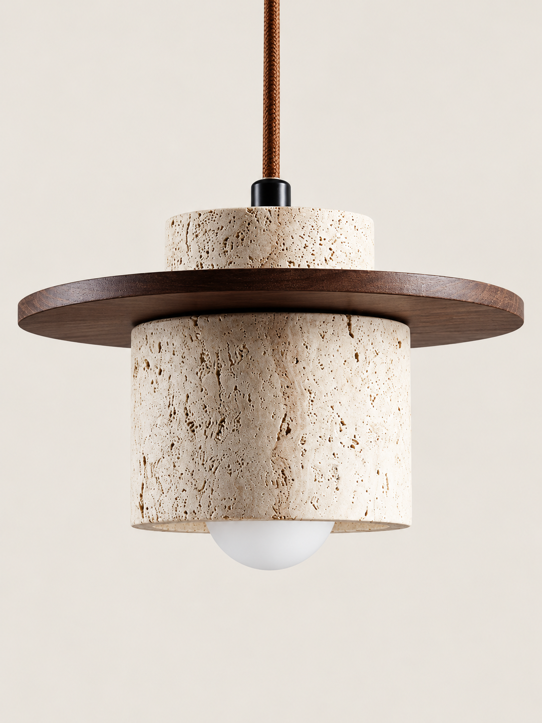Travertine and wood pendant, dark walnut tone, single stone-cylinder shade with a flat wood disc, cord and projecting white bulb, fixture switched off