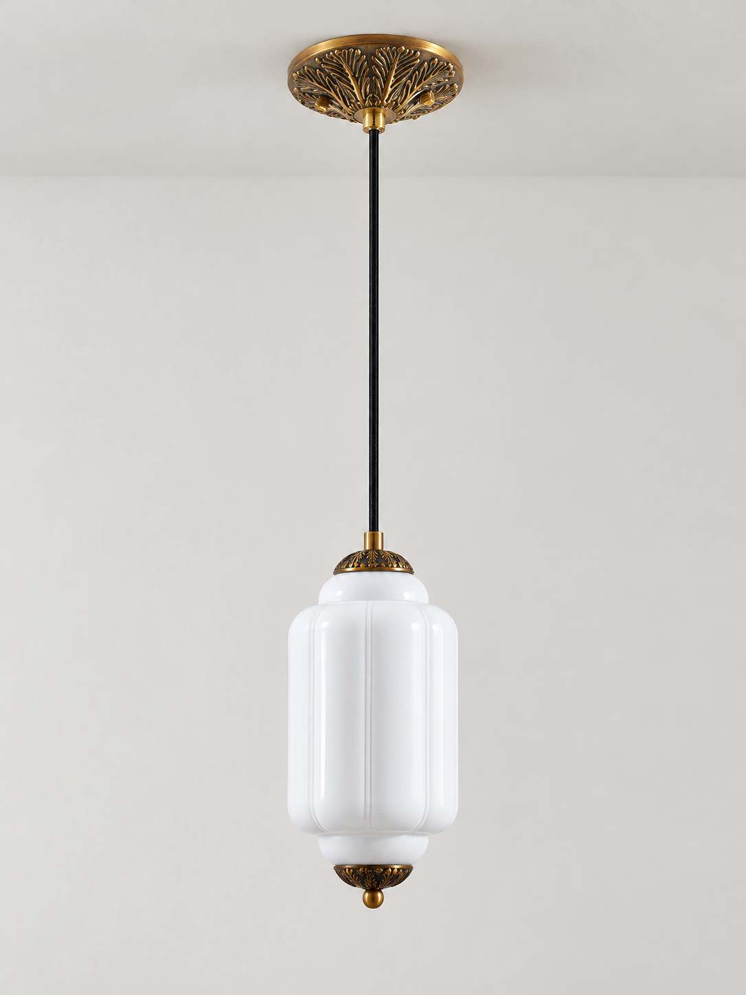 White ribbed glass pendant with copper-tone hardware and embossed canopy, shown switched off in daylight