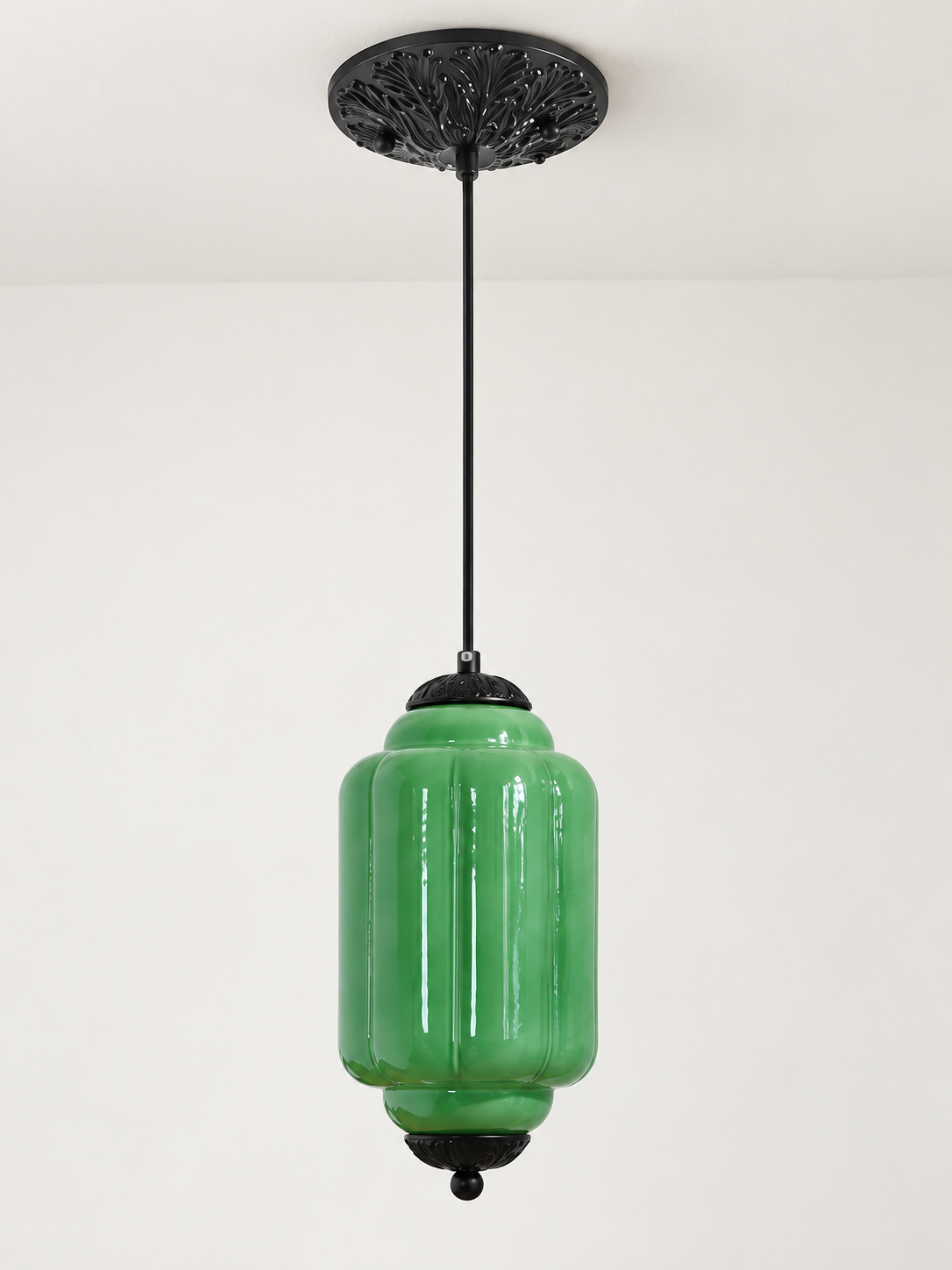 Green ribbed glass pendant with black hardware and embossed canopy, shown switched off in daylight
