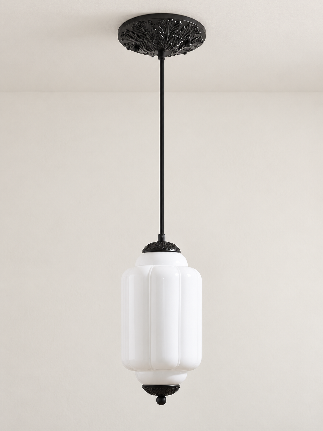 White ribbed glass pendant with black hardware and embossed canopy, shown switched off in daylight