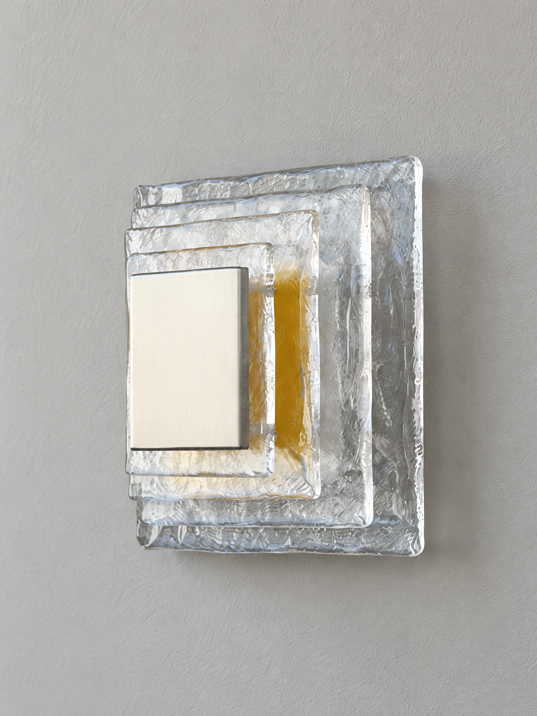 Small wall sconce with clear textured glass and yellow acrylic insert behind a brushed-metal cover, shown switched off in daylight