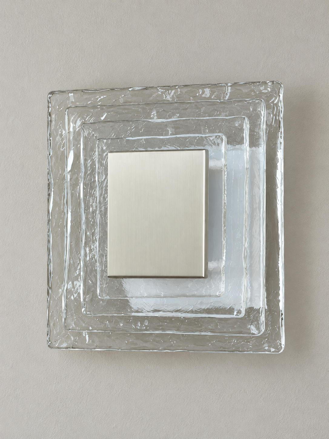 Large wall sconce with clear textured glass and white acrylic insert behind a brushed-metal cover, shown switched off in daylight