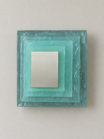 Large wall sconce with blue textured glass and yellow acrylic insert behind a brushed-metal cover, shown switched off in daylight