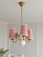 Copper-tone and white 3-light chandelier with red-and-white striped fabric shades, shown switched off