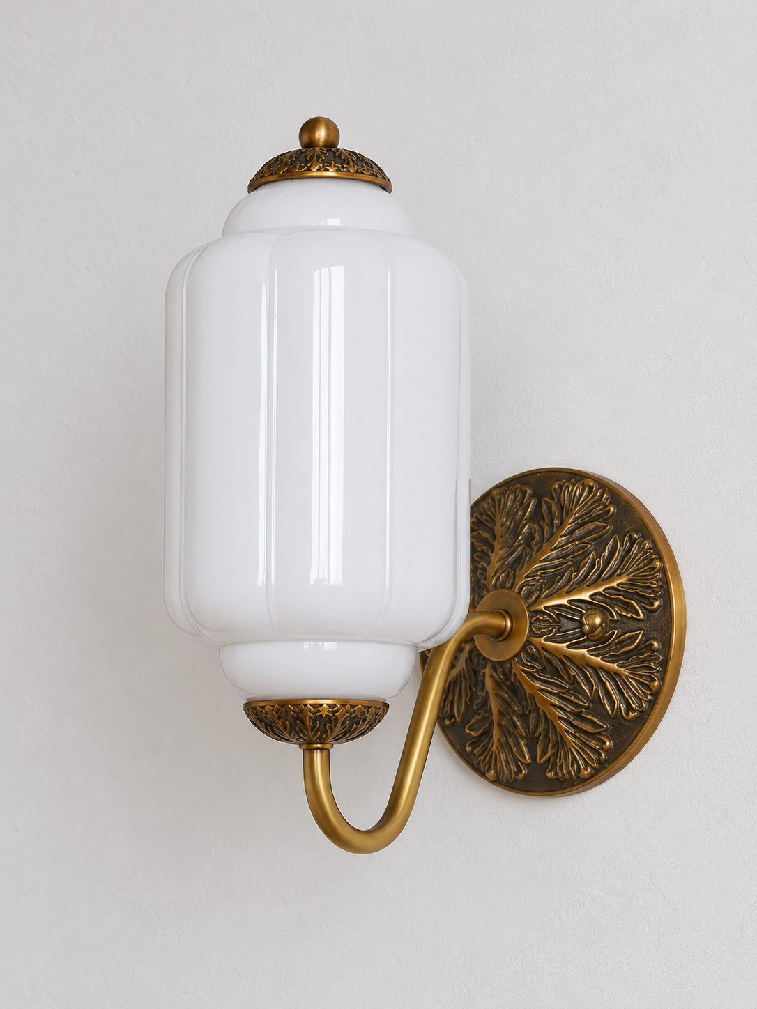 White ribbed glass wall sconce with copper-tone U-arm and ornate round medallion backplate, shown switched off