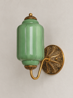 Green ribbed glass wall sconce with copper-tone U-arm and ornate round medallion backplate, shown switched off
