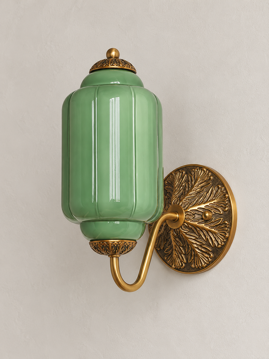 Green ribbed glass wall sconce with copper-tone U-arm and ornate round medallion backplate, shown switched off