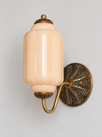 Melon ribbed glass wall sconce with copper-tone U-arm and ornate round medallion backplate, shown switched off