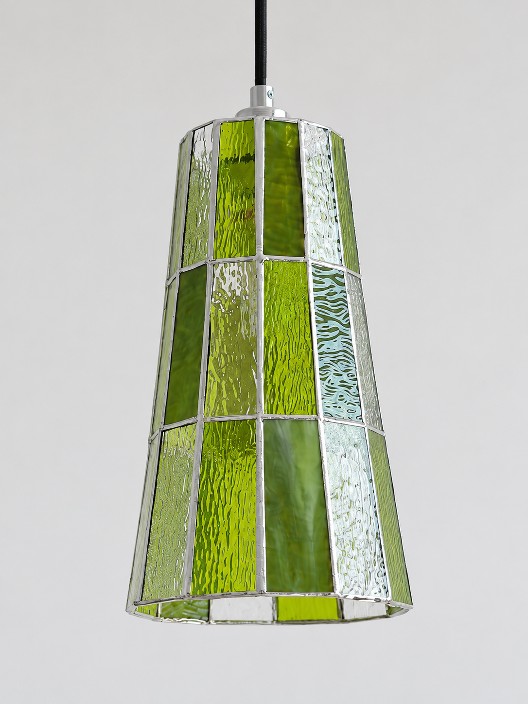 Close view of the green textured mosaic glass shade with silver-tone seams, shown switched off