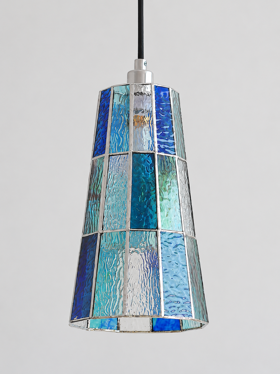 Close view of the blue textured mosaic glass shade with silver-tone seams, shown switched off