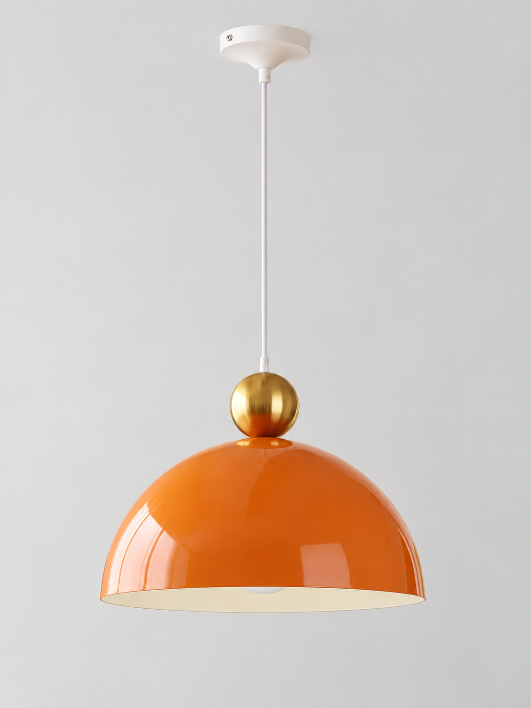 Orange 35 cm metal dome pendant with a gold-tone orb, white cord and canopy, shown switched off