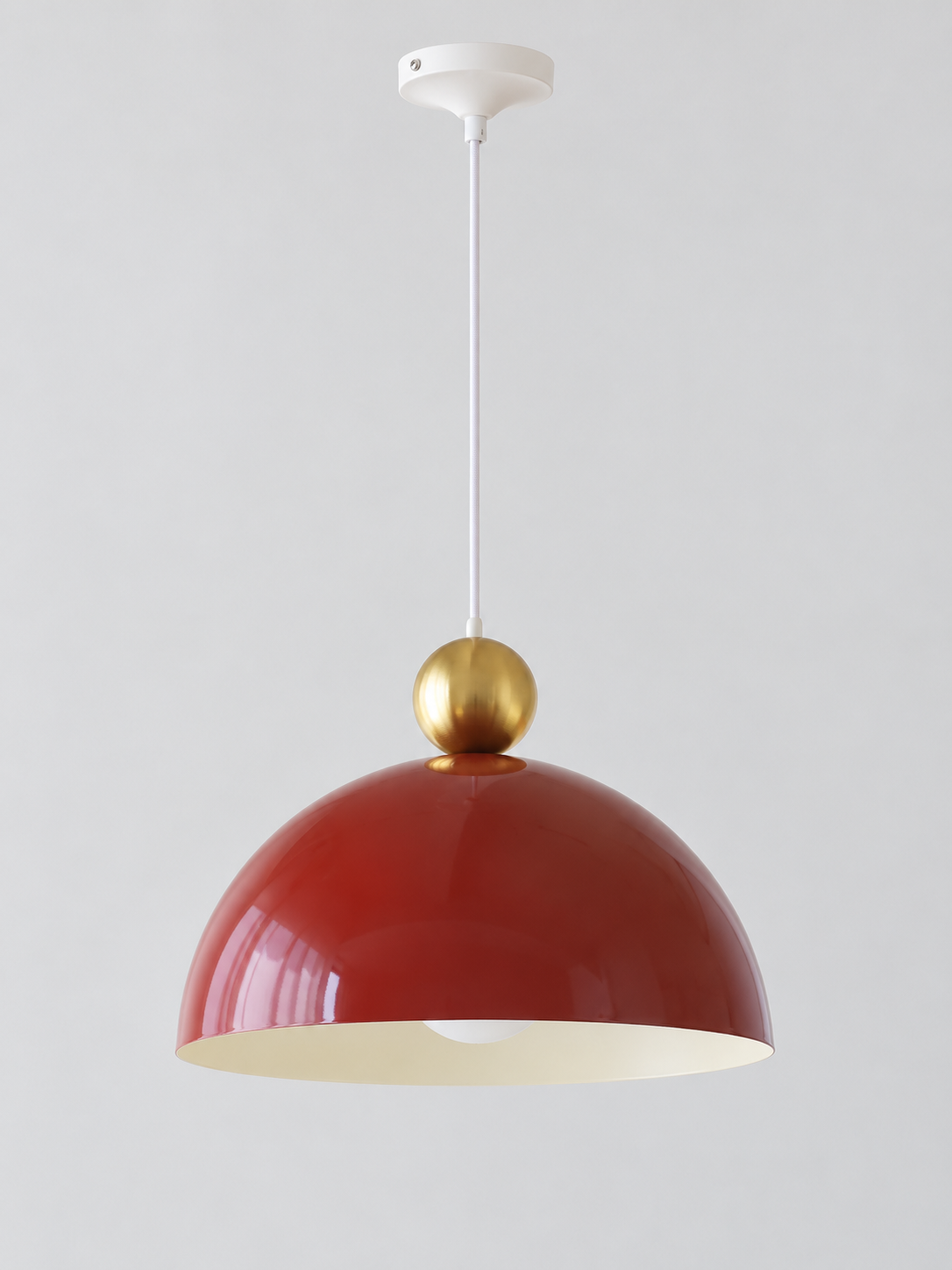 Cherry Red 35 cm metal dome pendant with a gold-tone orb, white cord and canopy, shown switched off