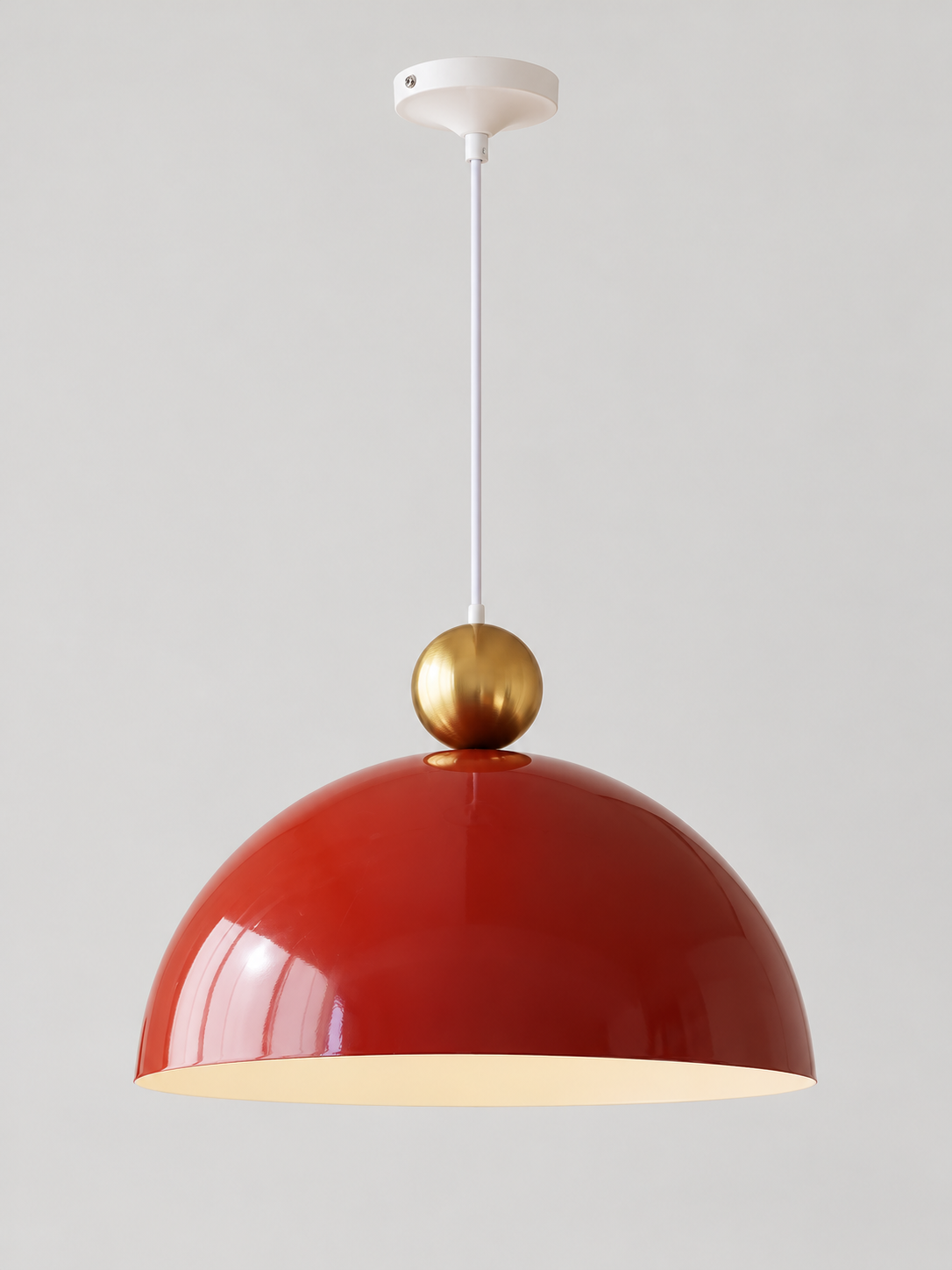 Cherry Red 40 cm metal dome pendant with a gold-tone orb, white cord and canopy, shown switched off