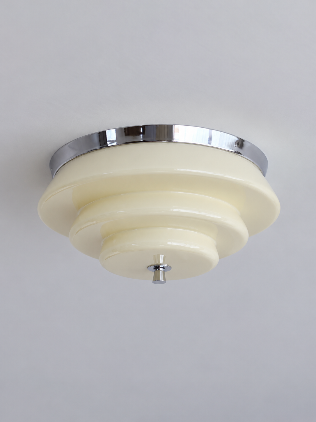 Chrome and cream stepped glass ceiling light, switched off against a neutral ceiling