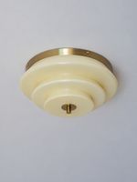 Bronze-tone and cream stepped glass ceiling light, switched off against a neutral ceiling