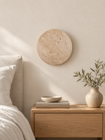 Travertine LED wall light in a bedside setting